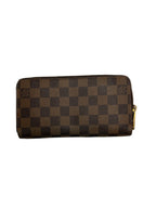 Front view of a Louis Vuitton Zippy Wallet in Damier Ebene canvas with gold-tone zip-around hardware.