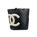 Front view of a Chanel Cambon Ligne Large Tote in black quilted leather with white CC logo on a white background.