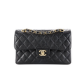 Black quilted handbag with gold chain and clasp on a white background