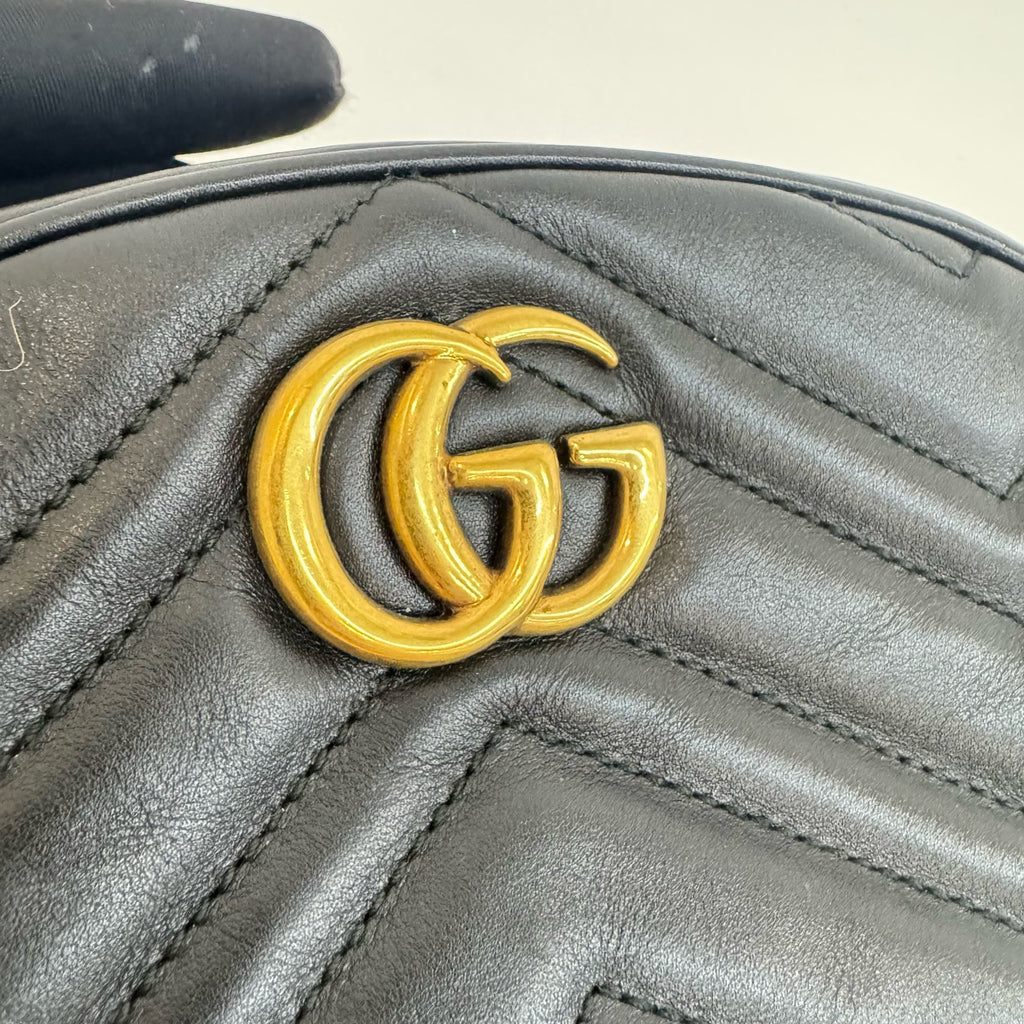Close-up of a black leather handbag with a gold Gucci logo.