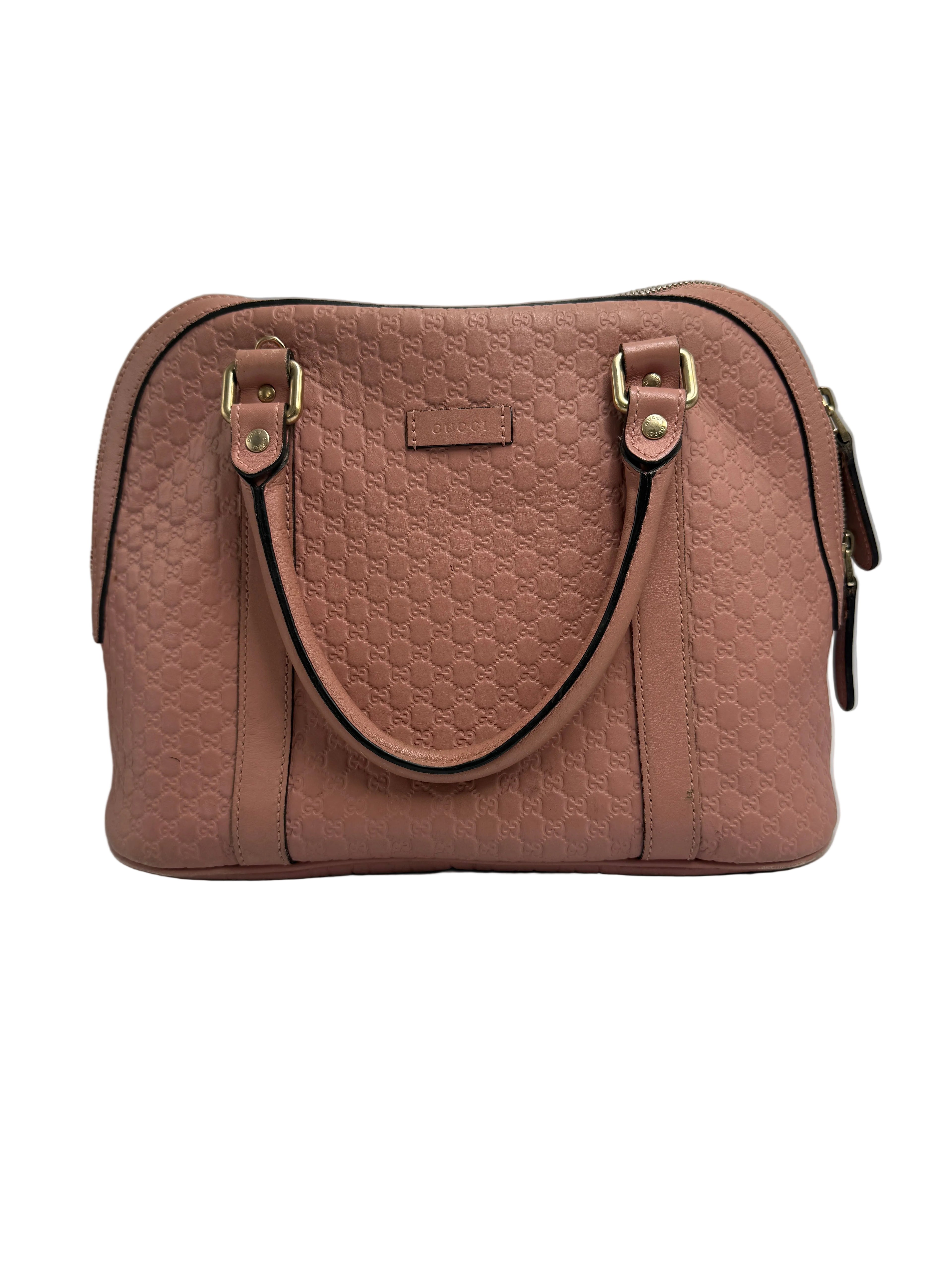 Front view of a Gucci medium dome bag in dusty pink Microguccissima embossed leather with rolled top handles and gold hardware.