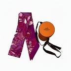 PRELOVED authentic hermes Colorful patterned twilly scarf with a round orange Hermès box in very good condition accessories