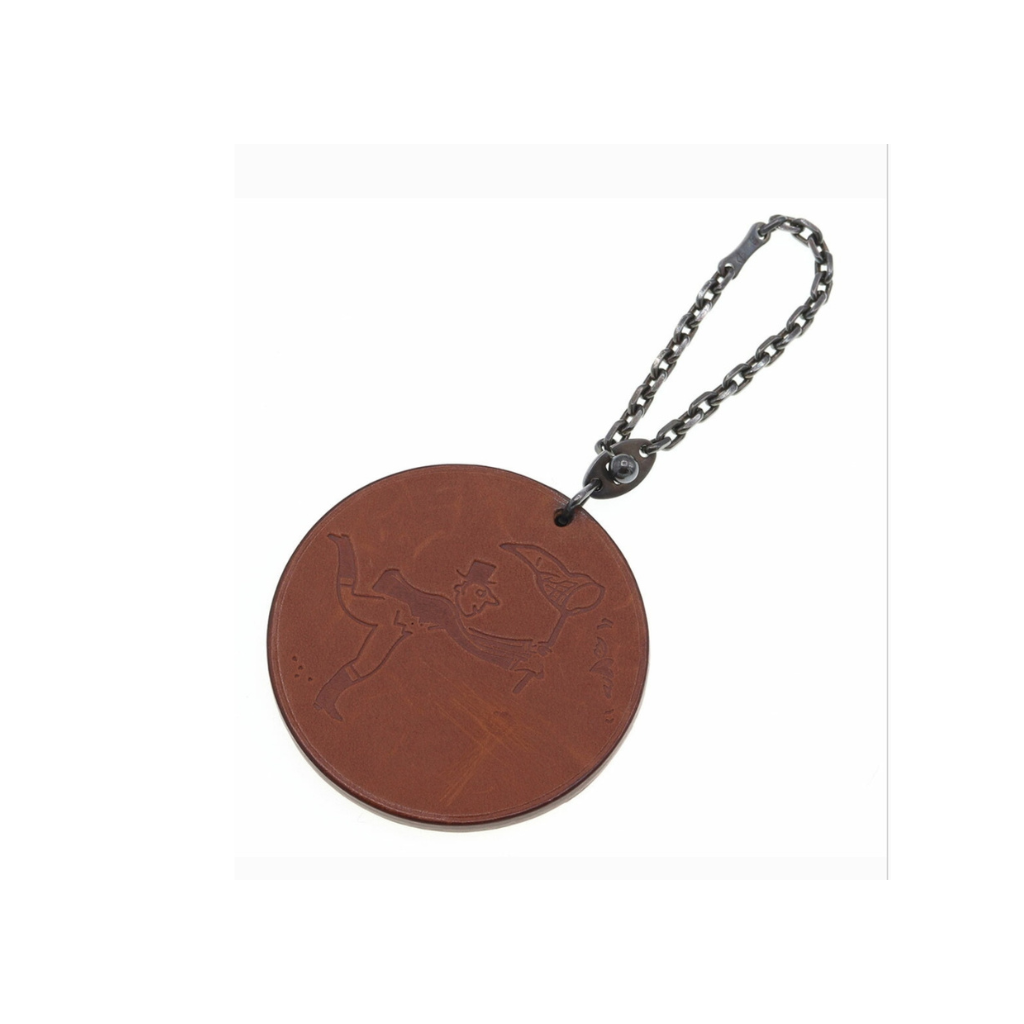 Brown leather keychain with a skull design on a white background