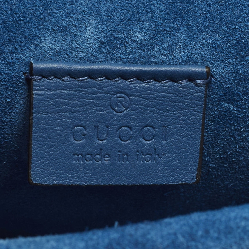 Gucci label on a blue textured surface