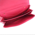 Close-up of a pink handbag with gold accents on a white background