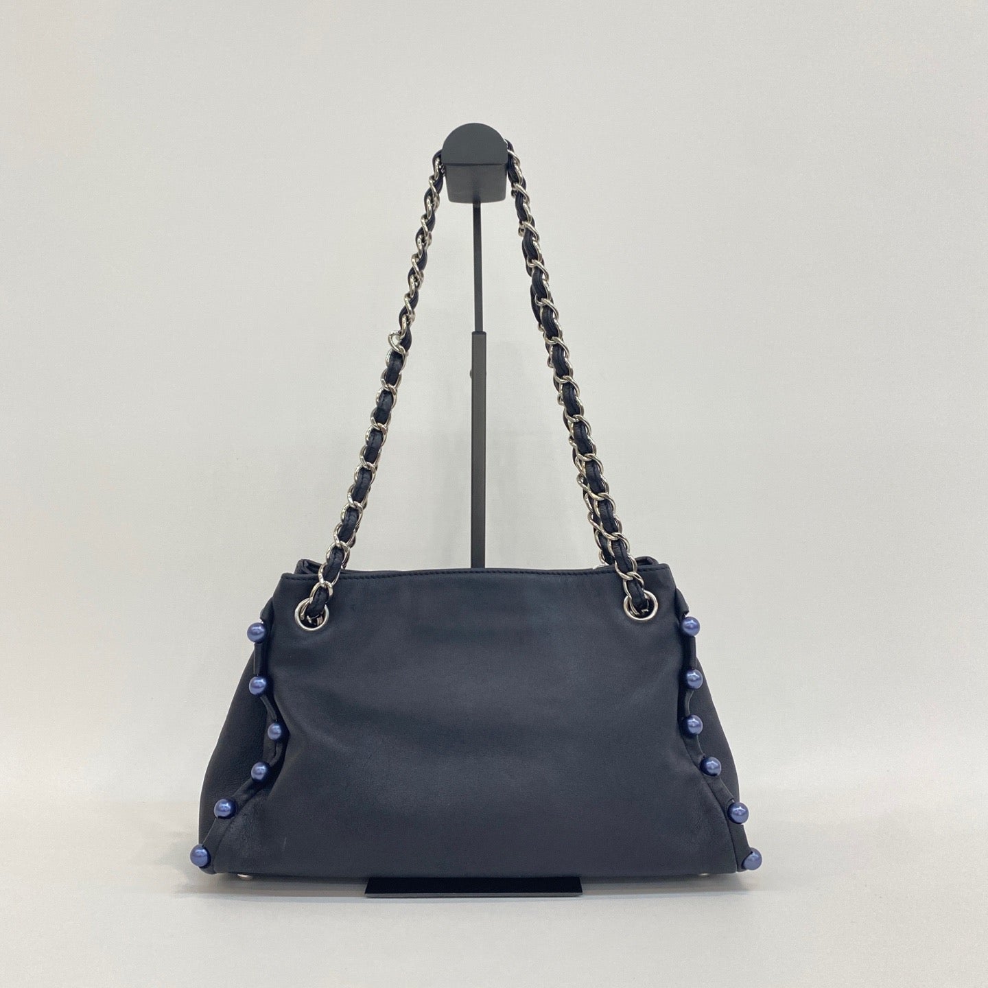 the back view of preowned chanel pearl obsession tote navy blue lambskin leather tote bag in great condition 
