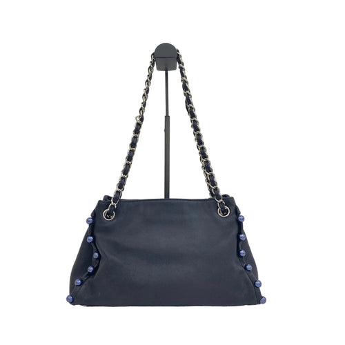 the back view of preowned chanel pearl obsession tote navy blue lambskin leather tote bag in great condition 