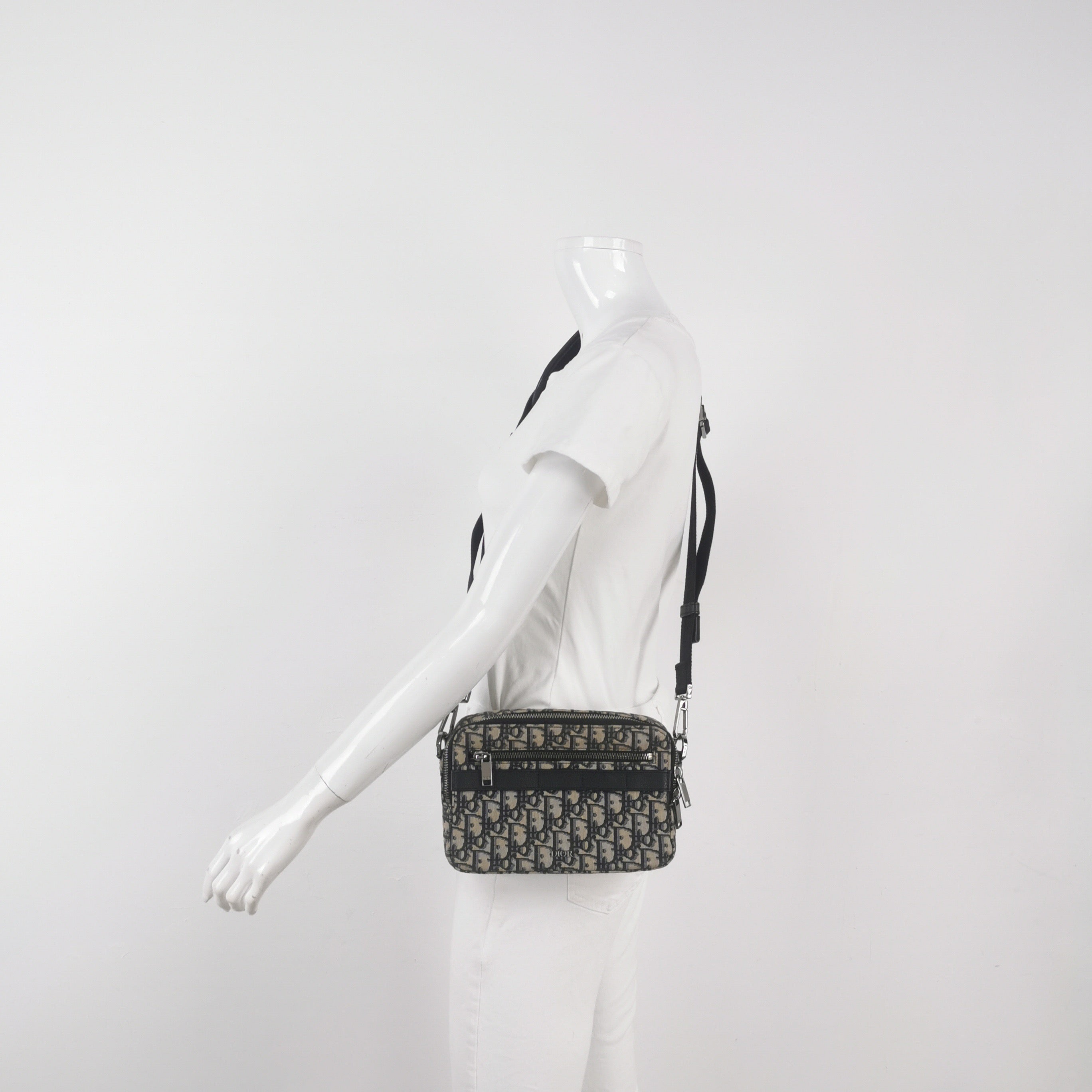 Mannequin wearing a black and white preowned christian dior oblique monogram crossbody waist bag with zipper closure