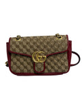 Front view of a Gucci GG Marmont shoulder bag in beige GG canvas with red leather piping and antique gold Double G logo clasp.