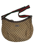 Front view of a Gucci half-moon shoulder bag in GG canvas with green and red Web strap and brown leather trim.