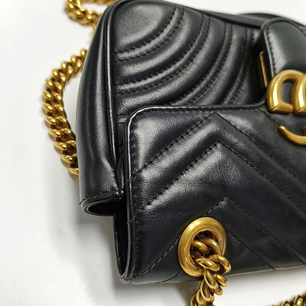 Black quilted handbag with gold chain strap on black leather gucci bag in good condition