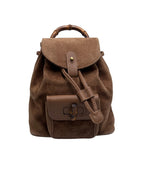Front view of a vintage Gucci small backpack in brown suede with bamboo top handle and bamboo turn-lock pocket.