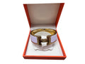Front view of a Hermès Clic Clac H wide enamel bracelet in pale pink and gold hardware displayed inside an orange Hermès box.