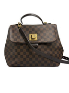 Front view of a Louis Vuitton Bergamo MM handbag in Damier Ébène canvas with a top handle, shoulder strap, and gold twist lock.