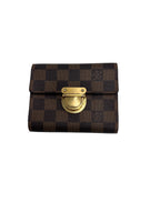 Front view of a Louis Vuitton Koala compact wallet in Damier Ebene canvas with golden brass push-lock closure