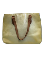 Front view of a Louis Vuitton Monogram Vernis Houston tote bag in light yellow patent leather with Vachetta straps