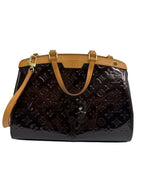 Louis Vuitton Monogram Pochette Accessoires handbag in dark brown patent leather with tan leather handles and trim, gold-tone hardware, and a matching shoulder strap, shown on a light gray background.