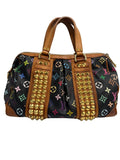 Louis Vuitton monogram canvas duffle bag with tan leather trim, gold-tone studs, and multicolor monogram motifs on a light gray background.