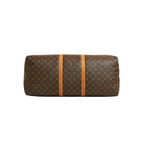 A Louis Vuitton monogram canvas duffel bag with two vertical tan leather straps, shown against a light gray background.