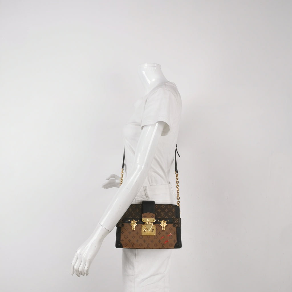 Mannequin wearing a preloved louis vuitton reverse monogram trunk clutch crossbody bag in great condition with gold hardware