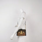 Mannequin wearing a preloved louis vuitton reverse monogram trunk clutch crossbody bag in great condition with gold hardware