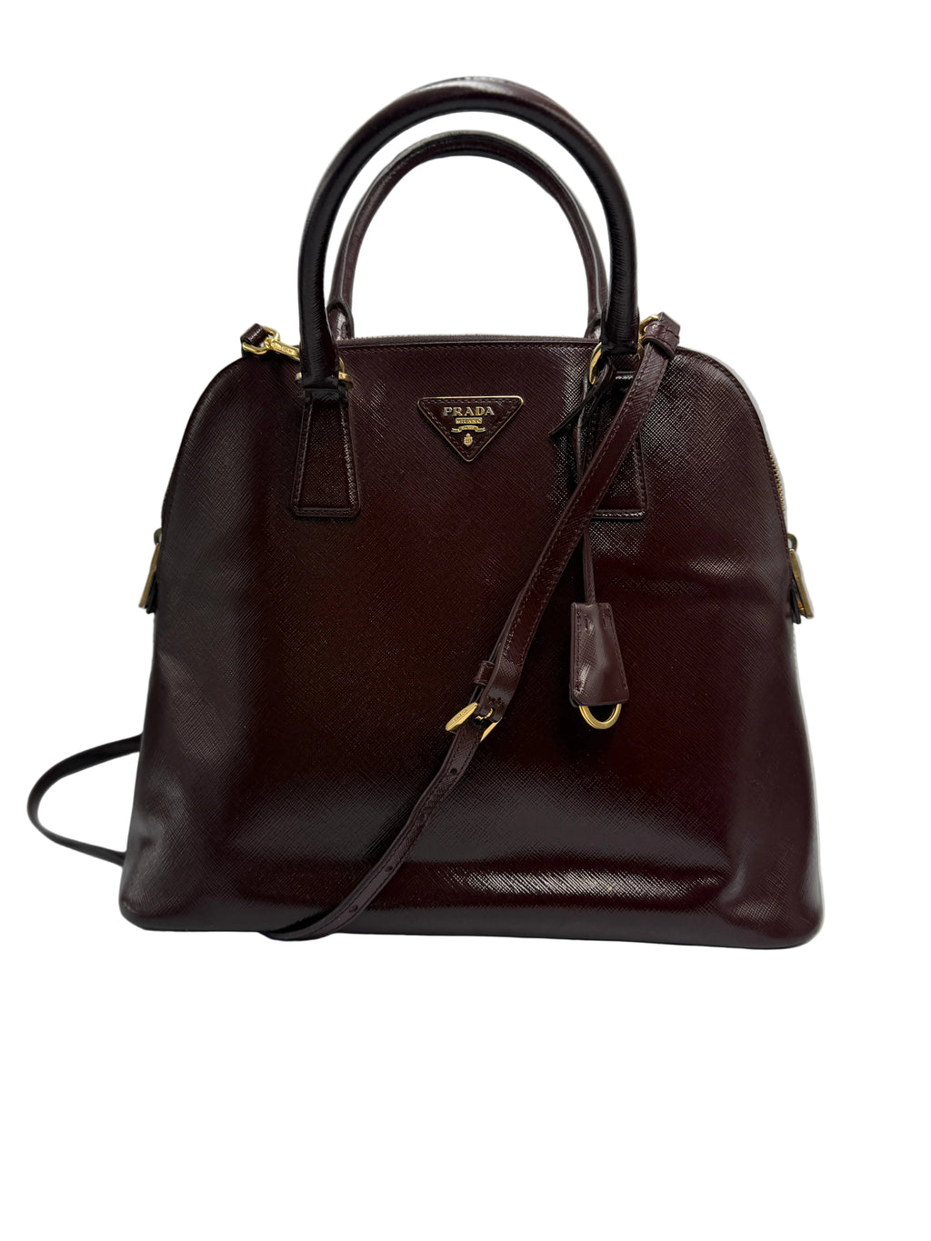 Front view of a Prada Promenade dome satchel in deep burgundy Saffiano leather with top handles, crossbody strap, and gold triangle logo.