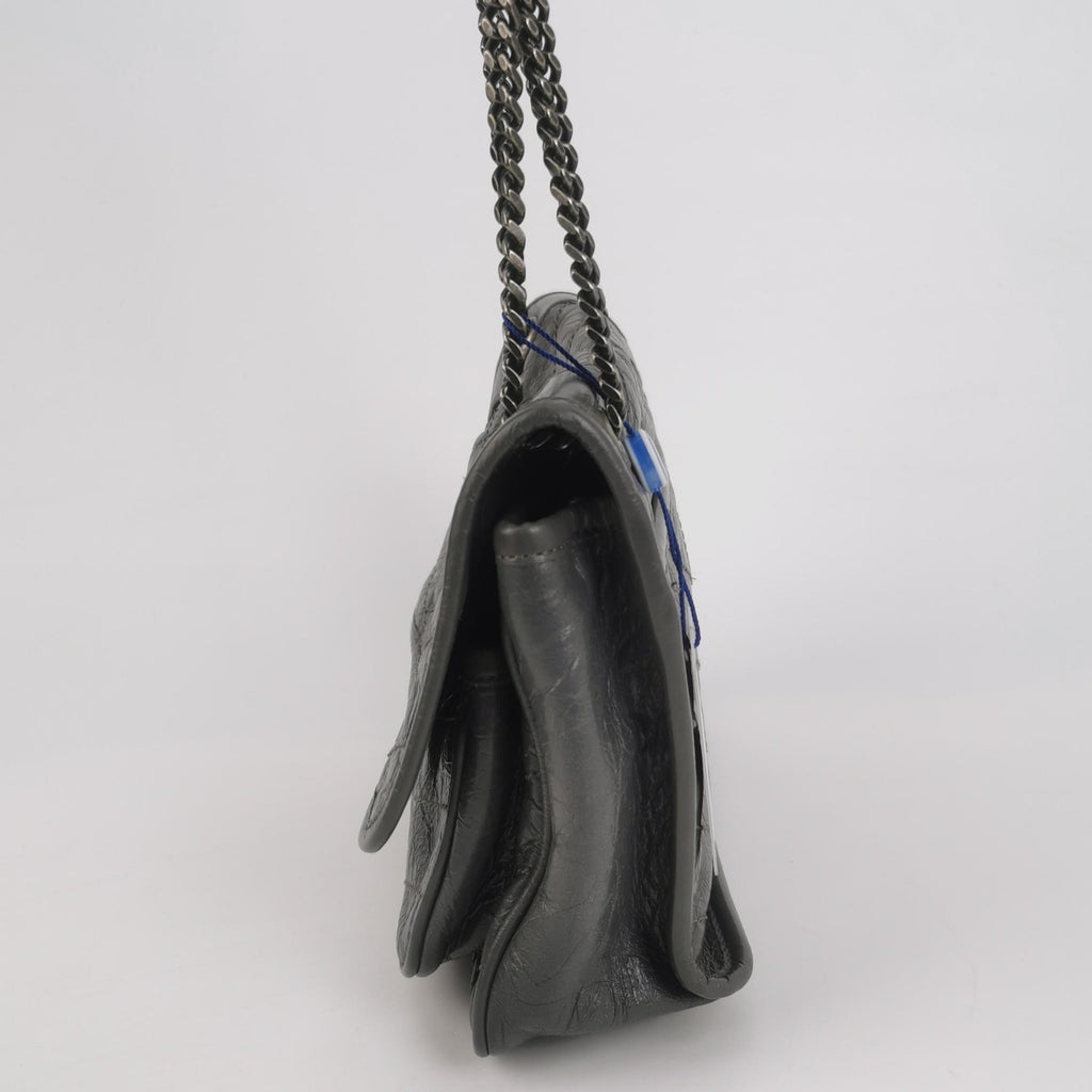 Grey saint laurent handbag with a chain strap on a light gray background