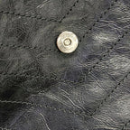 Close-up of a black leather saint laurent niki medium with a brand logo on a textured surface